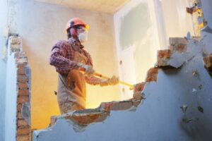 Worker,With,Sledgehammer,At,Indoor,Wall,Destroying
